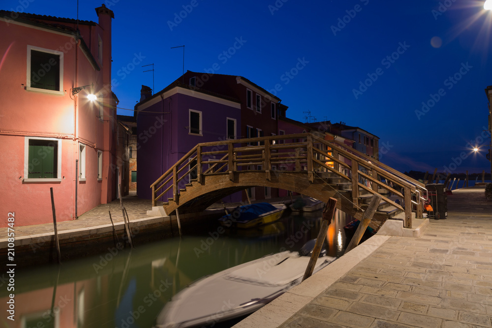 Old colorful houses and boats at night in Burano, Venice Italy.
