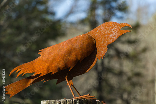 A rusty stamped metal crow or bird.