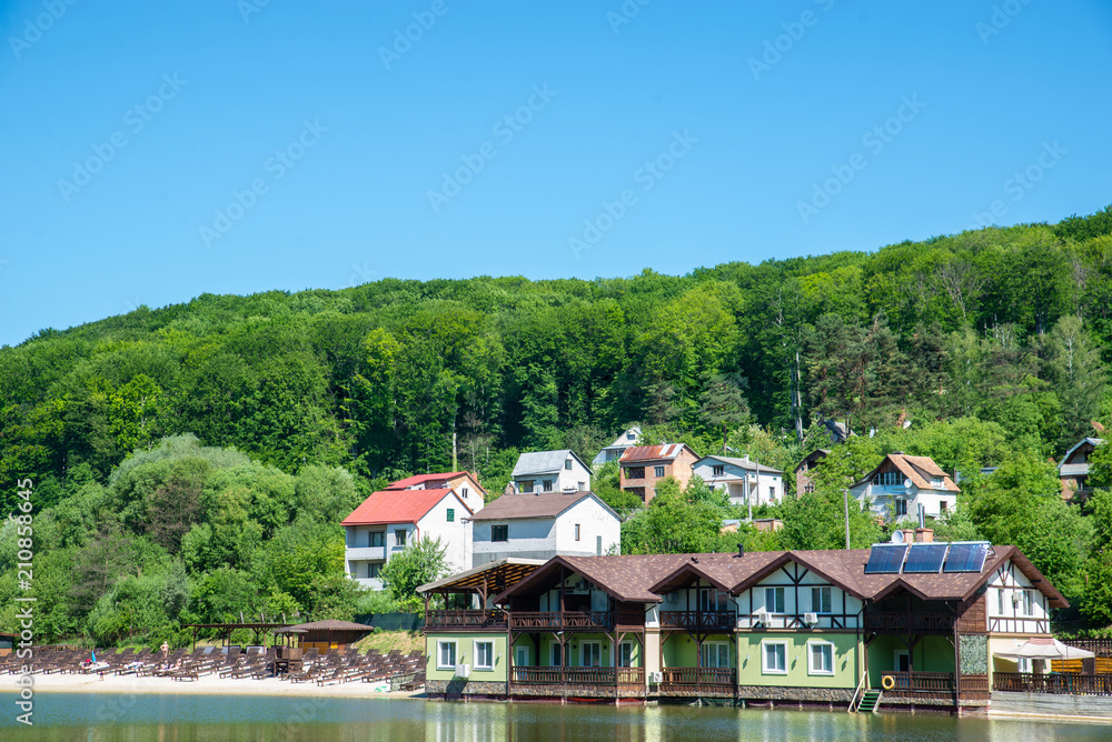 cottage on river side in sunny day with sand beach.