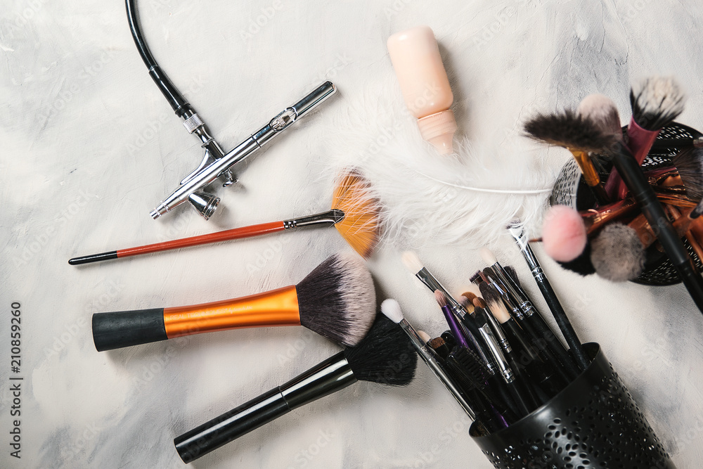 Makeup tools for professional makeup artist. Makeup brushes. Airbrush and  jar of paint. Makeup tools and accessory on concrete gray background.  Fashion and beauty concept Stock Photo | Adobe Stock
