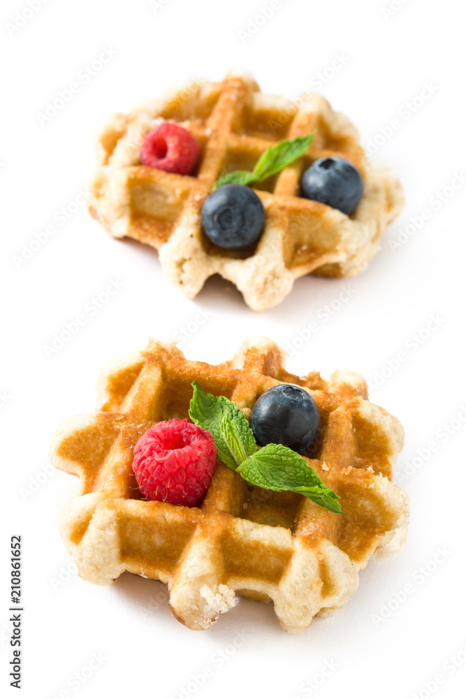 Traditional belgian waffles with blueberries and raspberries isolated on white background. Traditional belgian waffles with blueberries and raspberries isolated on white background.