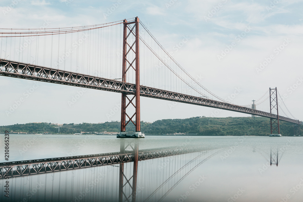 Bridge called April 25 in Lisbon in Portugal with reflection in water Bridge called April 25 in Lisbon in Portugal with reflection in water