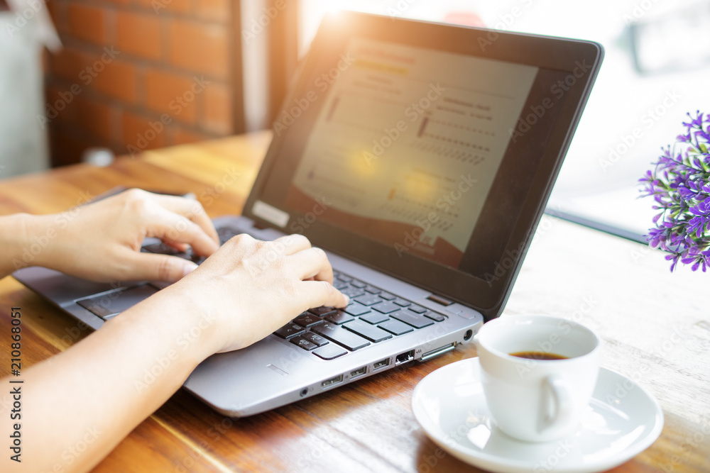 Business woman hand working laptop computer in office.On the table are coffee mugs and phones. Business woman hand working laptop computer in office.On the table are coffee mugs and phones.