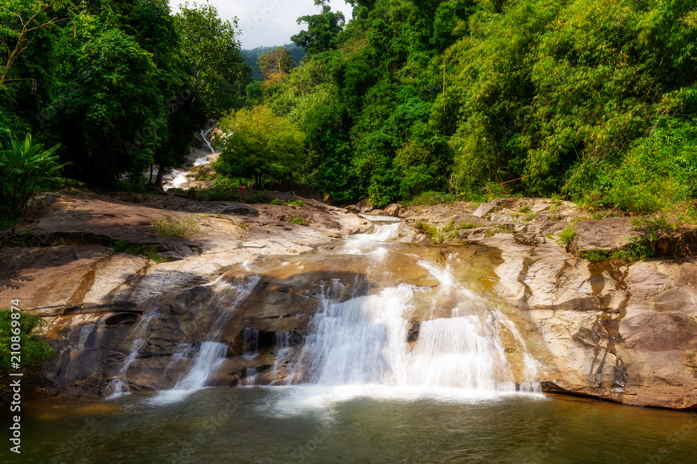 Obraz premium Water fall in forest with green tree landscape