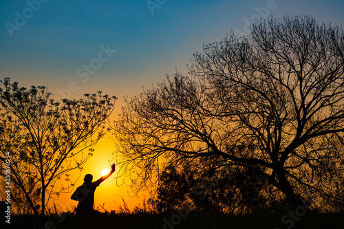 Man meditating in the field at sunrise