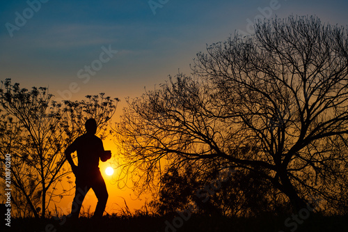 Man meditating in the field at sunrise