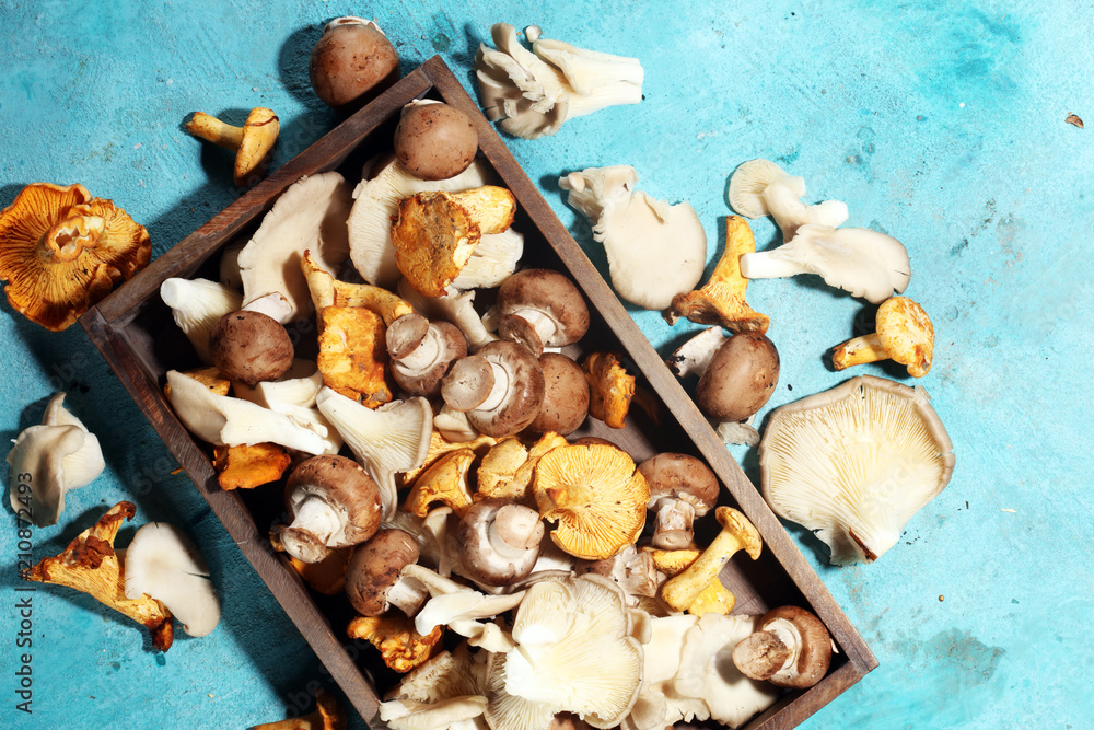 Wicker tray with variety of raw mushrooms on table. Wicker tray with variety of raw mushrooms on table.
