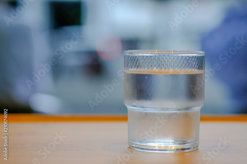 Close up of glass of cold water on wooden table.
