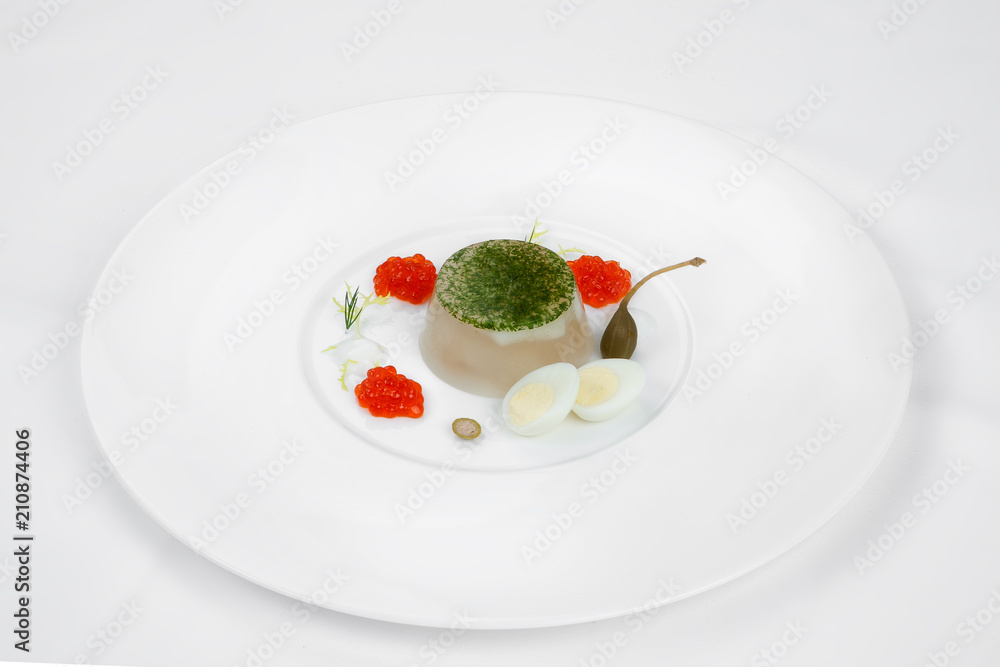 A beautiful dish from jellied fish with red caviar, egg and olive. A beautiful dish from jellied fish with red caviar, egg and olive.