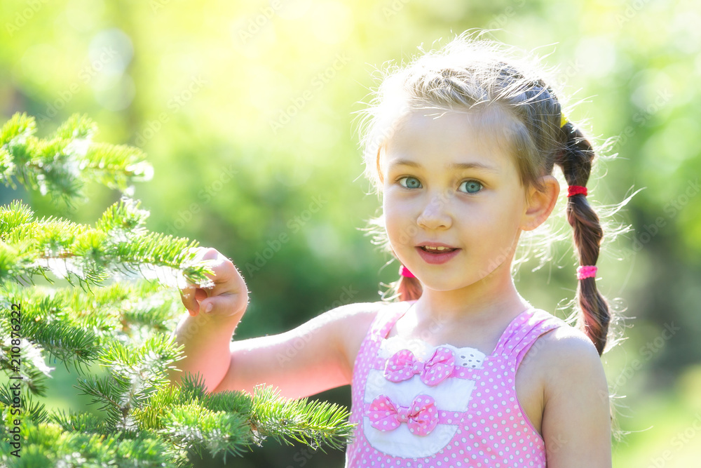 A 5 year old girl in a pink dress in the forest. A little girl with long braids of hair is standing near a tree ate. A 5 year old girl in a pink dress in the forest. A little girl with long braids of hair is standing near a tree ate.