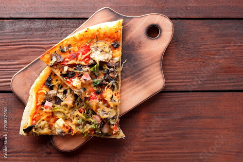 Pizza slices on a wooden board, Italian pizza on a wooden background top view, Italian food in vintage style, appetizing dish for summer vacation, American food, copy space, American food