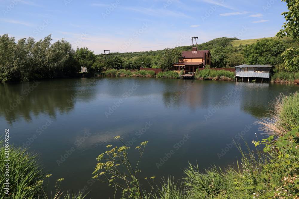 Wooden hut on the shore of a small pond