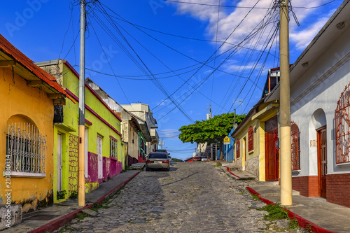 Obraz na płótnie Guatemala. Flores, El Peten. The old part of the city in colonial style with narrow cobblestone streets, red-roofed buildings and pastel houses w salonie