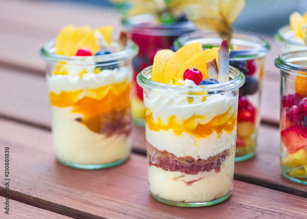Dessert Nachspeise im Glas mit Crumble, Creme, Früchten, Mango, Biskuit ...