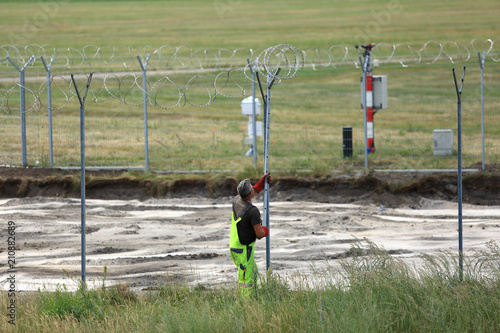 Budowa ogrodzenia, zakładanie drutu kolczastego wokół lotniska w Pyrzowicach.