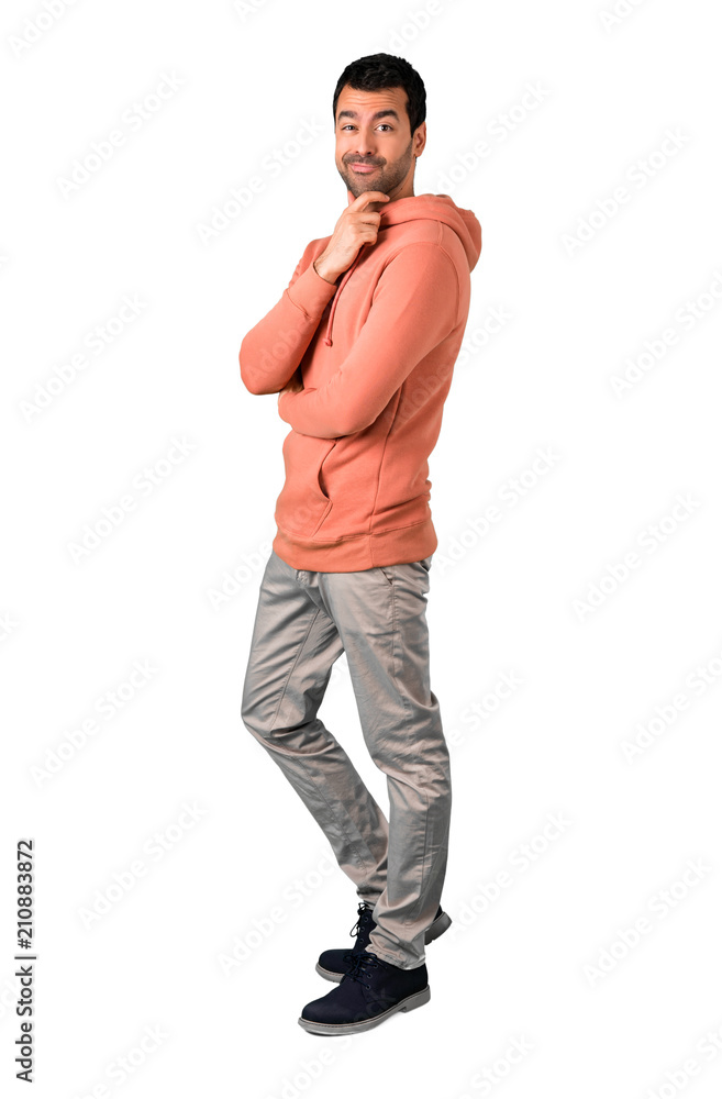 Full body of  Man in a pink sweatshirt smiling a lot while putting hands on chest on isolated white background