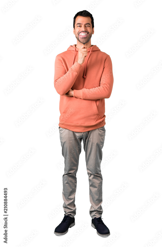 Fototapeta premium Full body of Man in a pink sweatshirt taking a magnifying glass and showing teeth through it on isolated white background