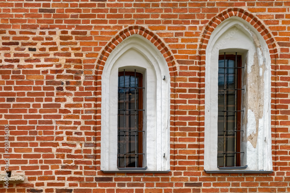 Arched windows with iron grill on an ancient red brick wall. Arched windows with iron grill on an ancient red brick wall.
