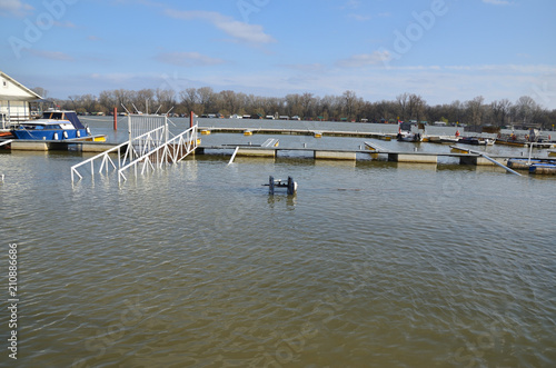 Flood over a promenade along a river bank in a city area