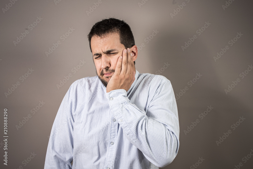 man in pain throwing his hand to his face