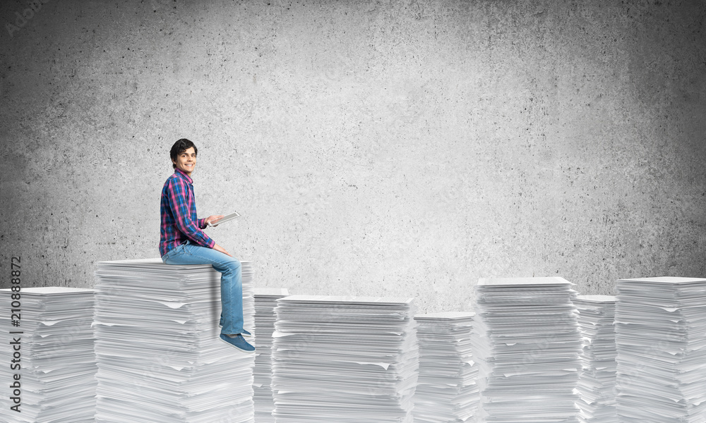 Attractive man sitting on pile of paper documents. Attractive man sitting on pile of paper documents.