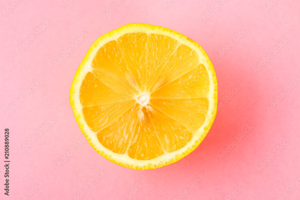 Top view of a one orange fruit slice on bright background in pastel color. Top view of a one orange fruit slice on bright background in pastel color.