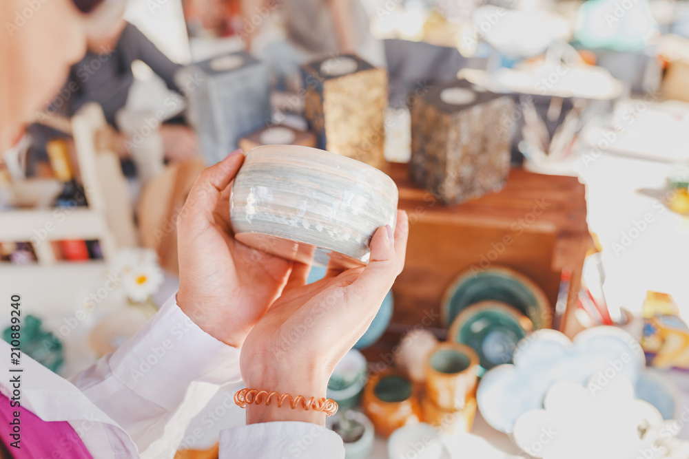 woman selecting ceramic tableware in the flea market
