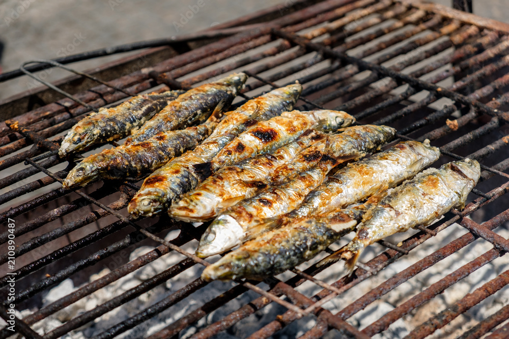 Grilled sardines and green peppers in Porto, Portugal on a grid grill, traditional food on festival Sao Joao