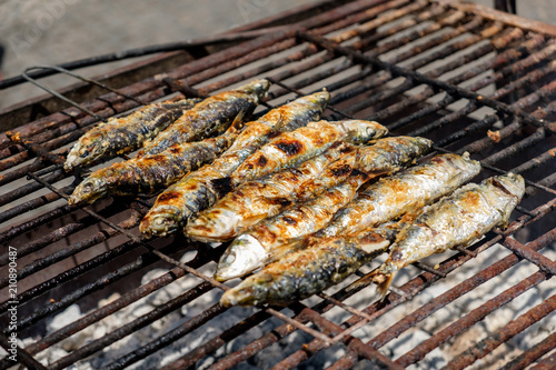 Grilled sardines and green peppers in Porto, Portugal on a grid grill, traditional food on festival Sao Joao