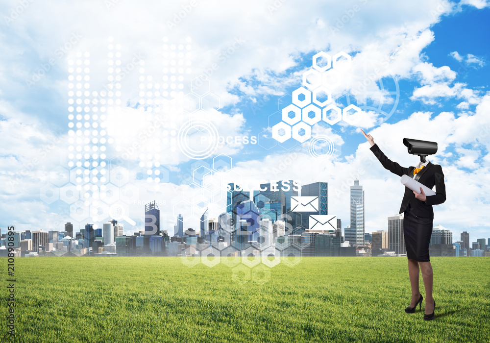 Camera headed woman standing on green grass against modern cityscape Camera headed woman standing on green grass against modern cityscape