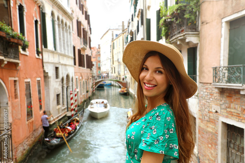 Smiling cheerful woman with hat and green dress in her venetian holidays. Happy attractive girl smile at camera in Venice, Italy. © zigres