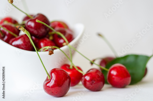 Cherries isolated. Cherries are in the white bowl on white background.