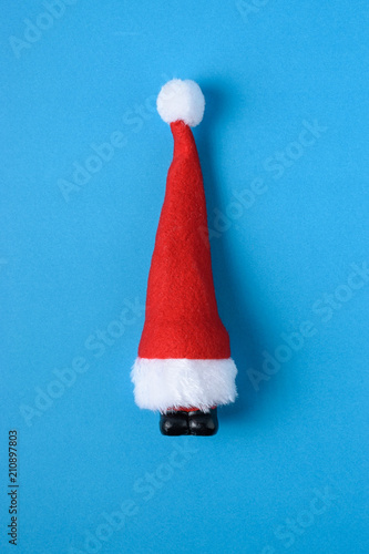 Miniature Santa Claus on blue background. Christmas New Year minimal concept.