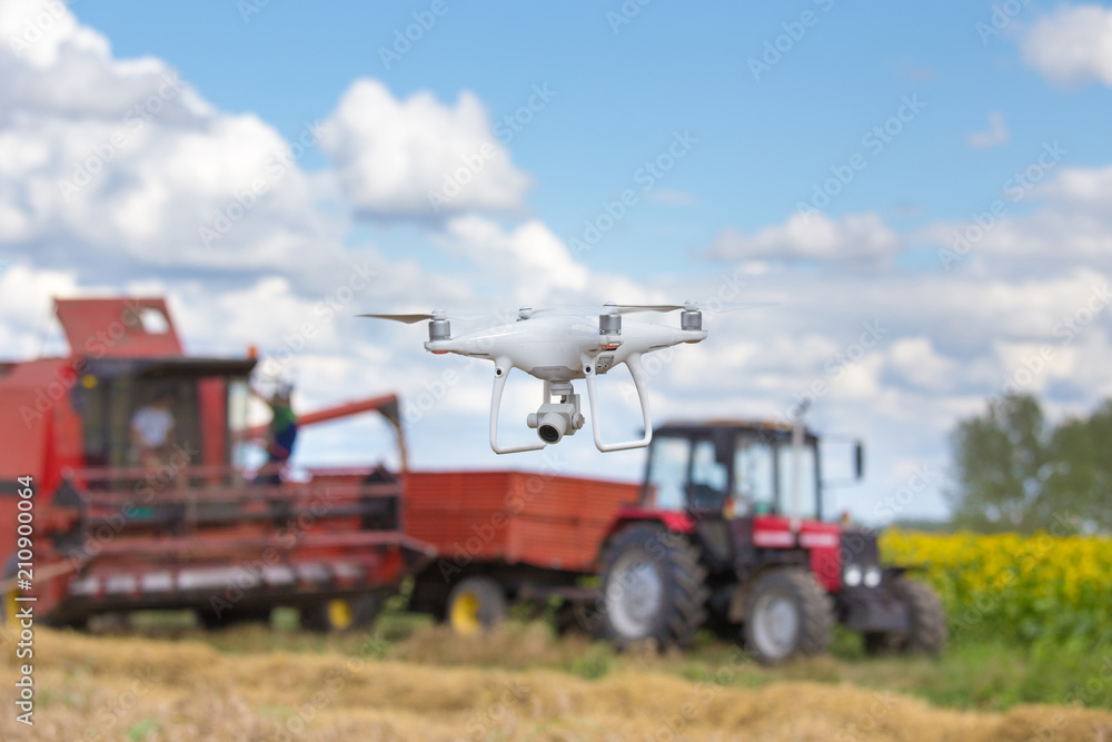 drone in front of tractor and combine harvester in field drone in front of tractor and combine harvester in field