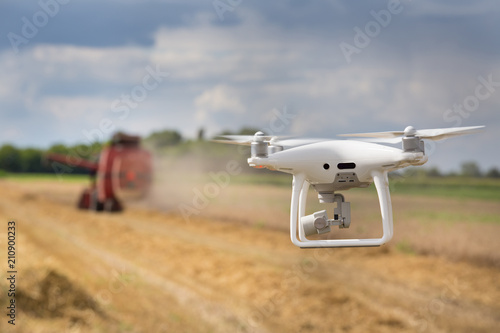 Drone flying in front of combine harvester