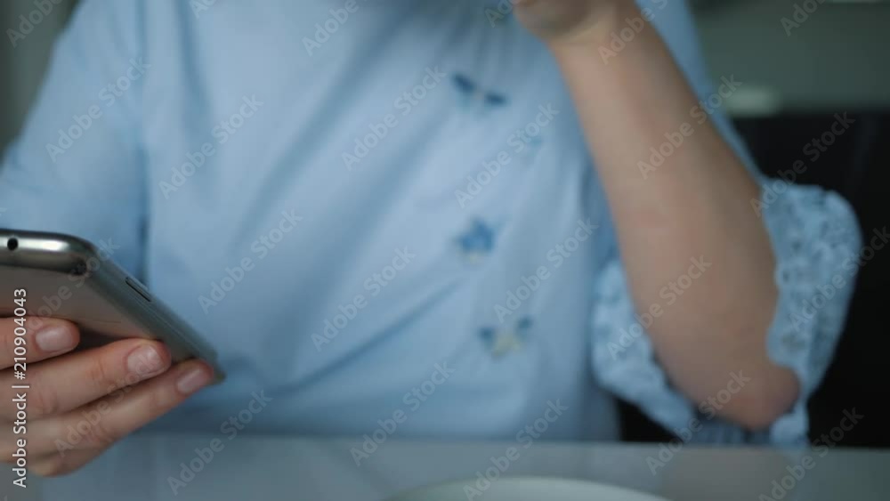 Close - up of a young girl, chooses a store with a smartphone for a Cup of coffee, technology and the concept of social networks. Close - up of a young girl, chooses a store with a smartphone for a Cup of coffee, technology and the concept of social networks.