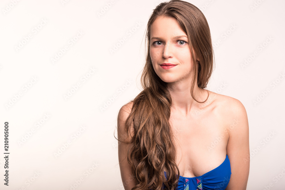 Fototapeta premium A girl in a blue swimsuit on a light background