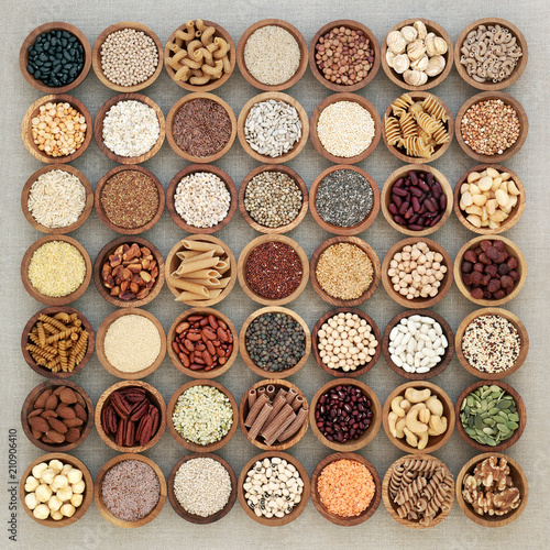 Fototapeta Naklejka Na Ścianę i Meble -  Vegan high protein dried health food with nuts, seeds, legumes, whole wheat pasta, grains & cereals. Foods high in fibre, antioxidants, anthocyanins, vitamins & minerals. Top view on hessian.