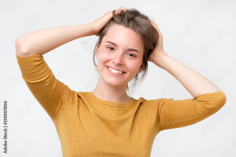 Young european woman in yellow sweater with beautiful smile in studio. Portrait on gray background. Fresh skin and perfect teeth concept Young european woman in yellow sweater with beautiful smile in studio. Portrait on gray background. Fresh skin and perfect teeth concept