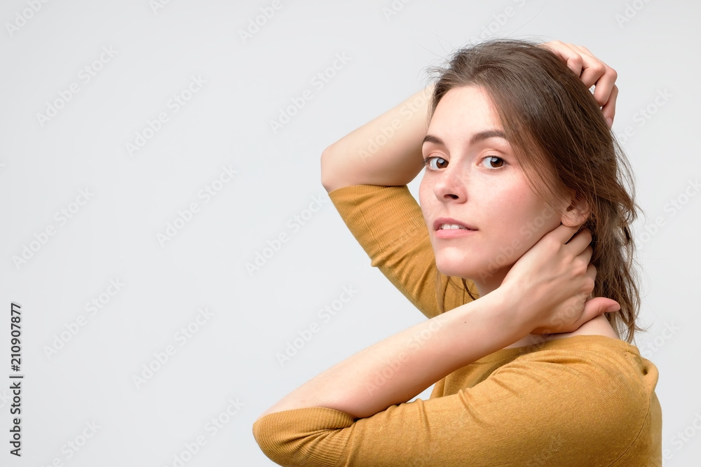 Young european woman in yellow sweater with beautiful smile in studio. Portrait on gray background. Fresh skin and perfect teeth concept Young european woman in yellow sweater with beautiful smile in studio. Portrait on gray background. Fresh skin and perfect teeth concept