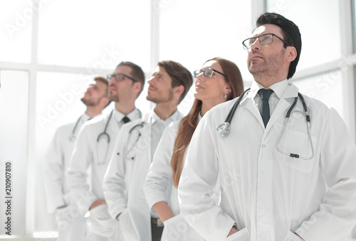 group of doctors standing in a row and looking at a copy space