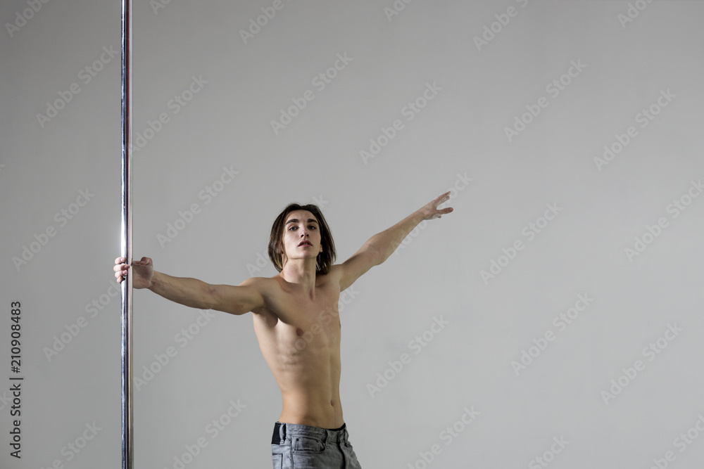 workout in dance studio. workout of man on pylon, copy space workout in dance studio. workout of man on pylon, copy space