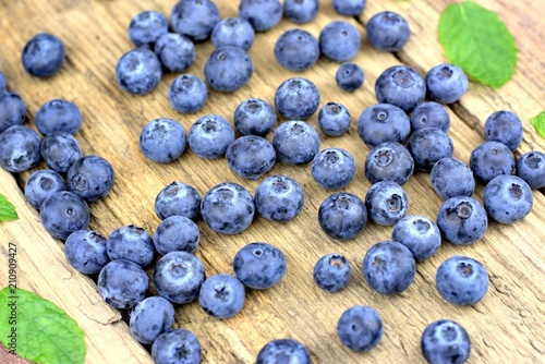 Healthy food,agriculture,harvest and fruit concept: ripe and fresh blueberries on an old wooden table.