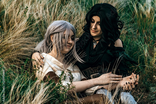 Fantasy cosplay two beautiful sit together in grass photo