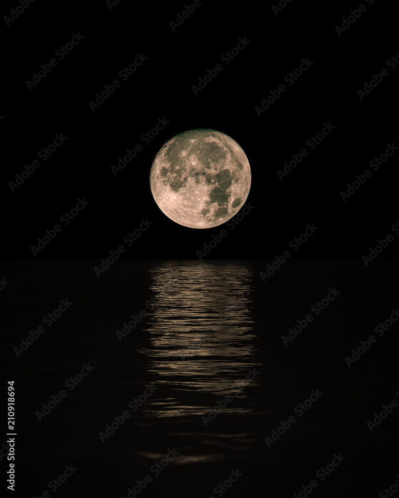 Full Moon Rising Over Calm Sea with reflection on water, Vertical