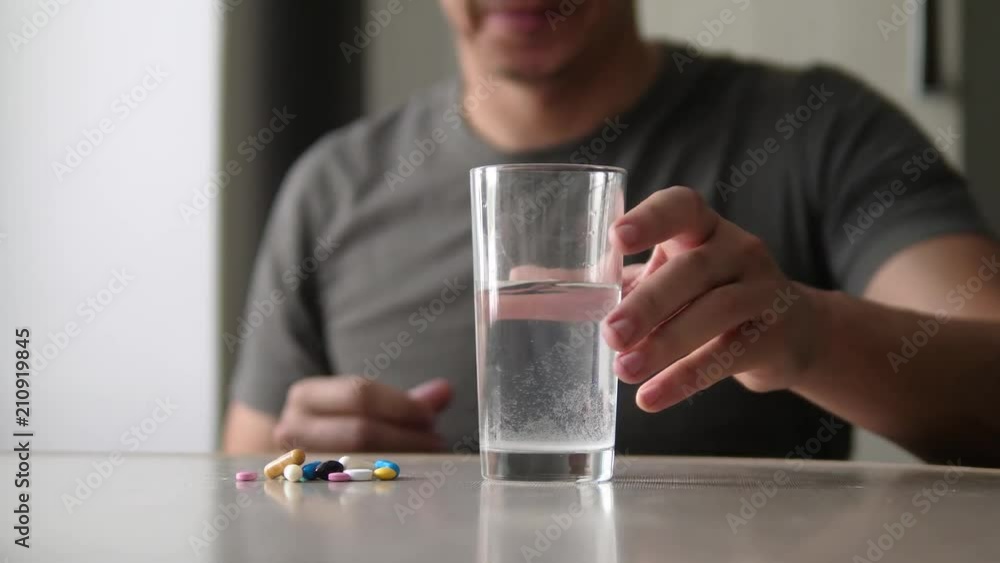 man taking pills at home is lifestyle ill sick slow motion video. Healthcare and medical concept disease. male takes a pill and drinks a glass of water indoors man taking pills at home is lifestyle ill sick slow motion video. Healthcare and medical concept disease. male takes a pill and drinks a glass of water indoors