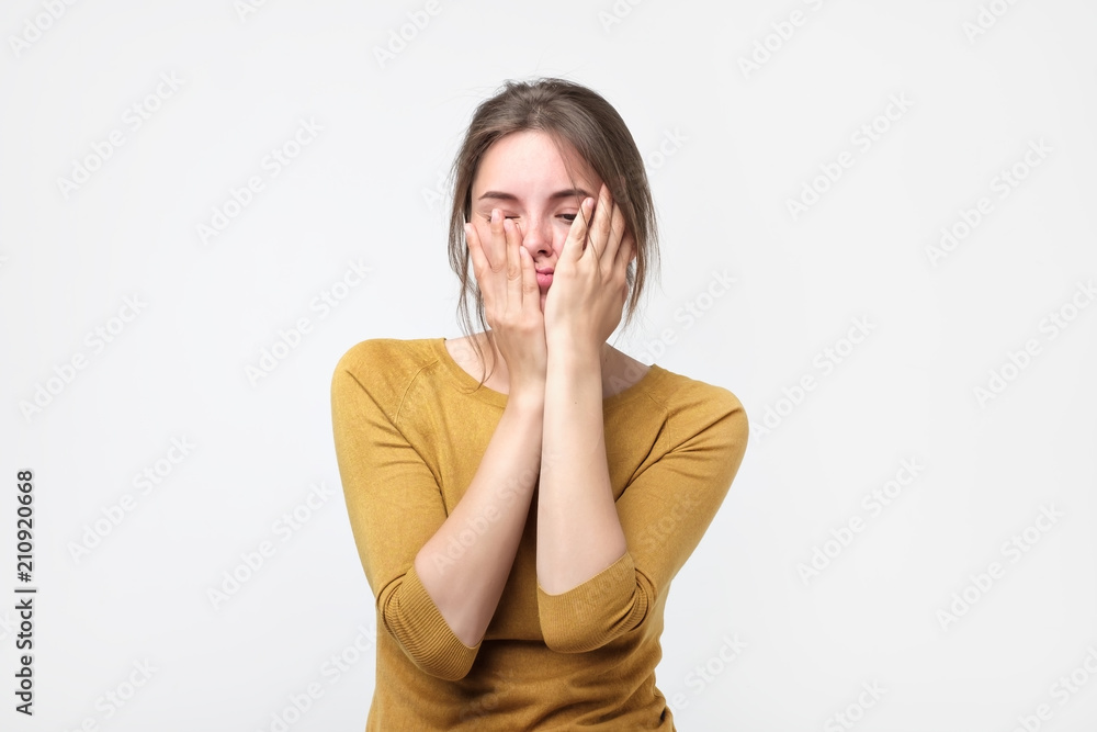 Exhausted young woman in yellow sweater touching her head with eyes closed. Female exchange worker suffering from insomnia. She is overworked. Preparing for difficult exam Exhausted young woman in yellow sweater touching her head with eyes closed. Female exchange worker suffering from insomnia. She is overworked. Preparing for difficult exam