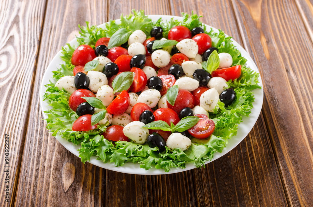 Salad with basil , tomatoes , olives and mozzarella