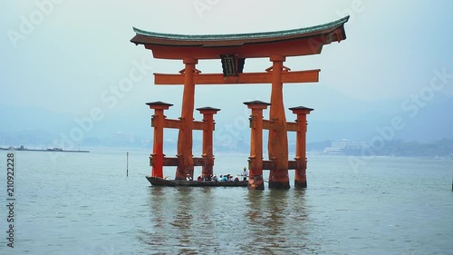 Miyajima, Japan - May, 2018: zoom in on boat passing under the famous floating torii in Miyajima