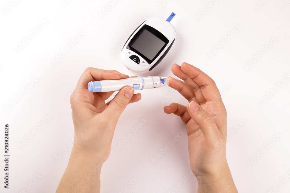 One person with diabetes doing a blood test with a glucometer isolated on white background One person with diabetes doing a blood test with a glucometer isolated on white background